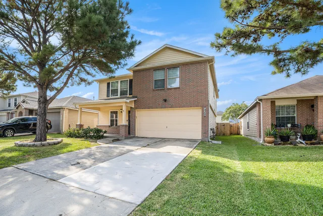 a front view of a house with a yard and trees
