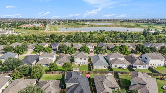 an aerial view of residential houses with outdoor space and ocean view