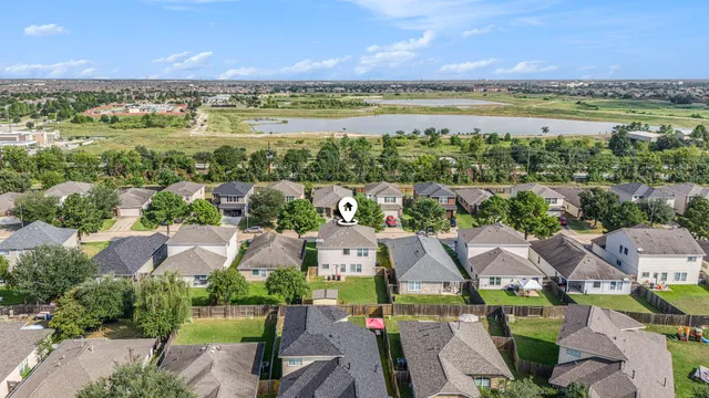 an aerial view of residential houses with outdoor space and ocean view