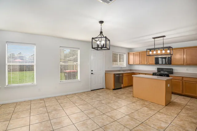 a kitchen with stainless steel appliances granite countertop a sink a stove top oven a counter space and cabinets