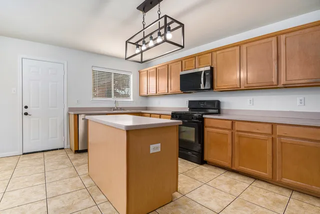 a kitchen with stainless steel appliances granite countertop a stove a sink and a microwave