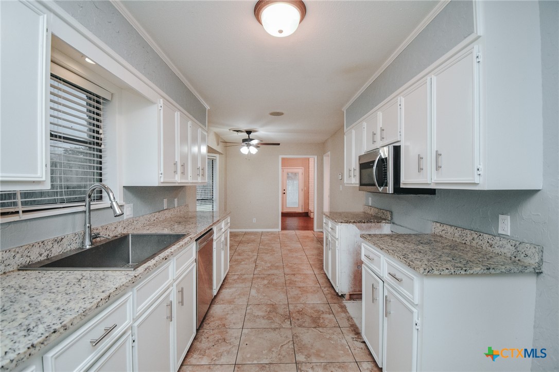 115 Santa Fe Victoria, TX 77904 - Photo 12 of 17 a kitchen with granite countertop a sink stove and cabinets
