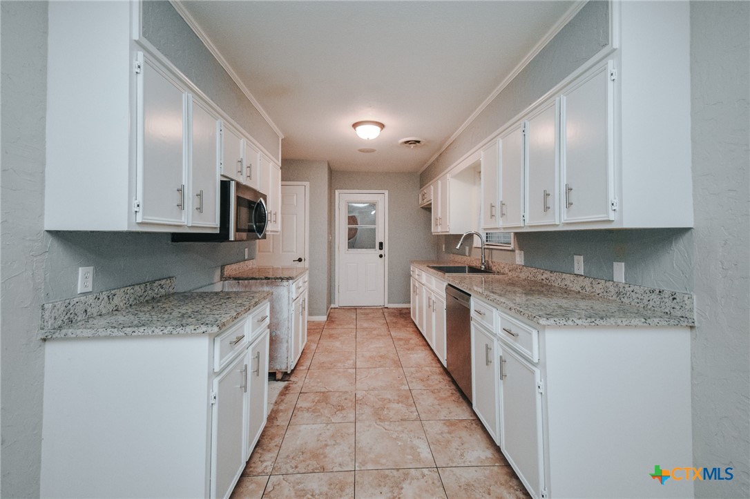 115 Santa Fe Victoria, TX 77904 - Photo 13 of 17 a kitchen with stainless steel appliances granite countertop a stove a sink and a microwave