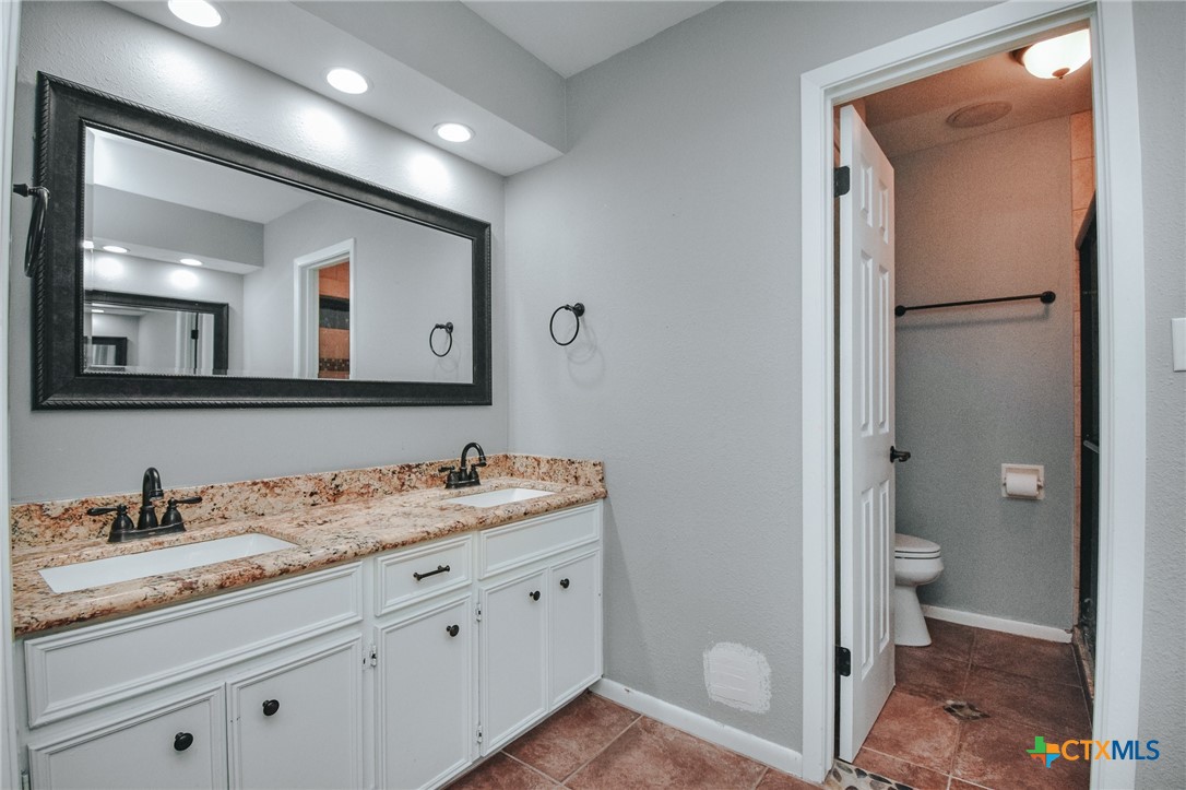 115 Santa Fe Victoria, TX 77904 - Photo 15 of 17 a en suite bathroom with a granite countertop sink and a mirror