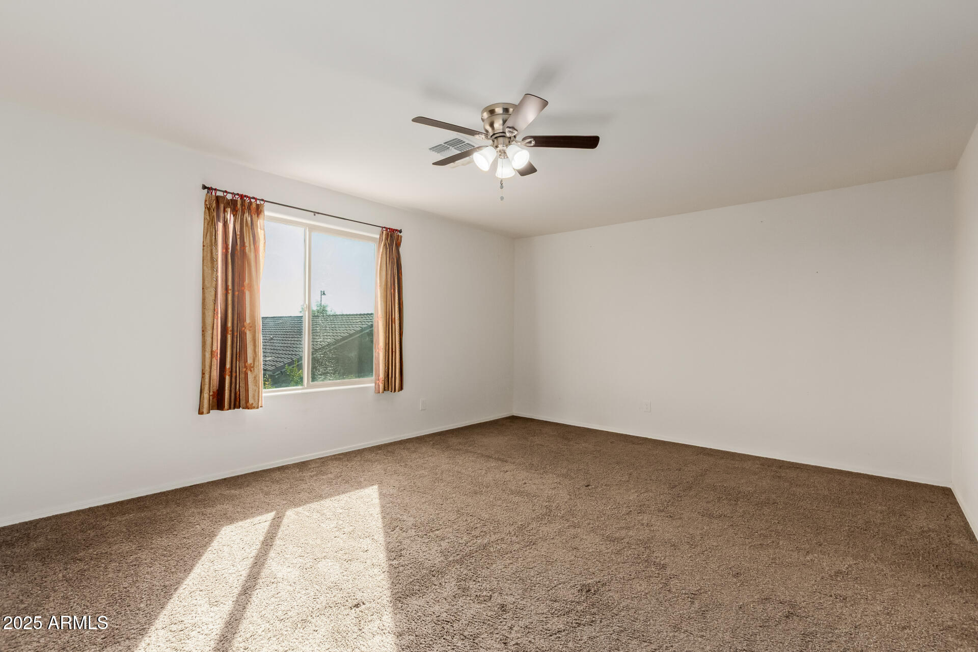 11603 West Calavar Road El Mirage, AZ 85335 - Photo 13 of 38 an empty room with windows and fan
