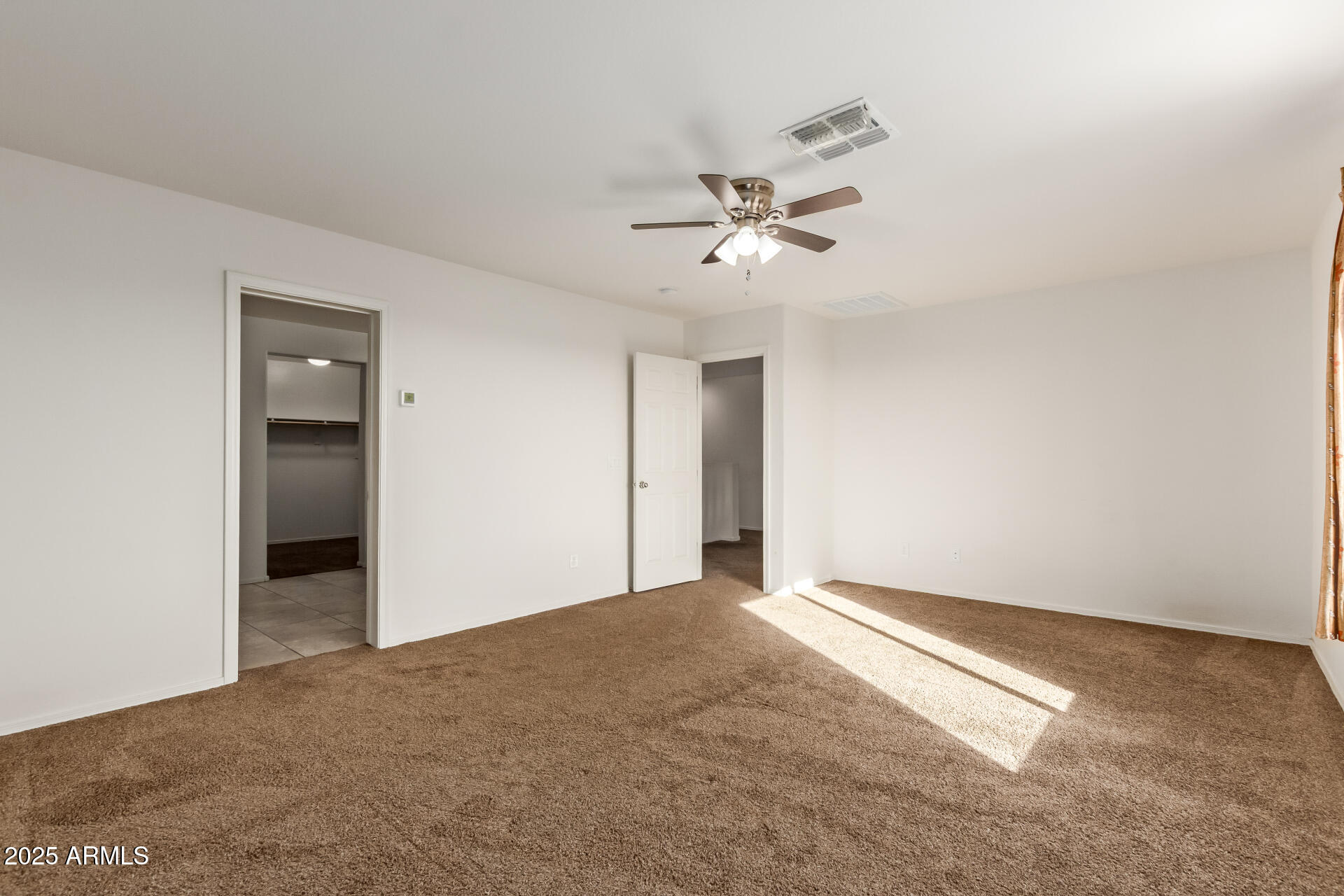 11603 West Calavar Road El Mirage, AZ 85335 - Photo 14 of 38 a view of an empty room with a fan