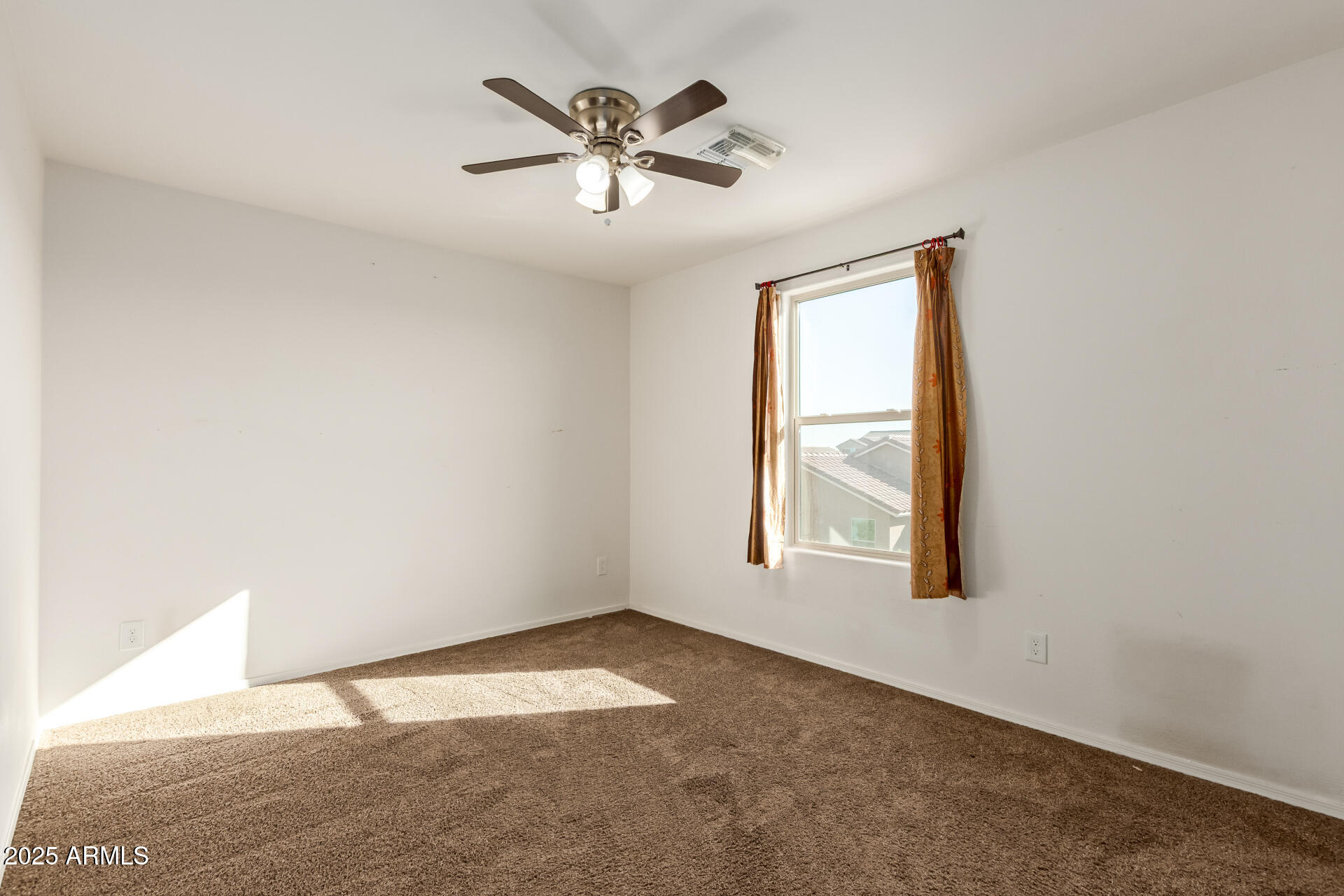 11603 West Calavar Road El Mirage, AZ 85335 - Photo 19 of 38 an empty room with a window and a ceiling fan