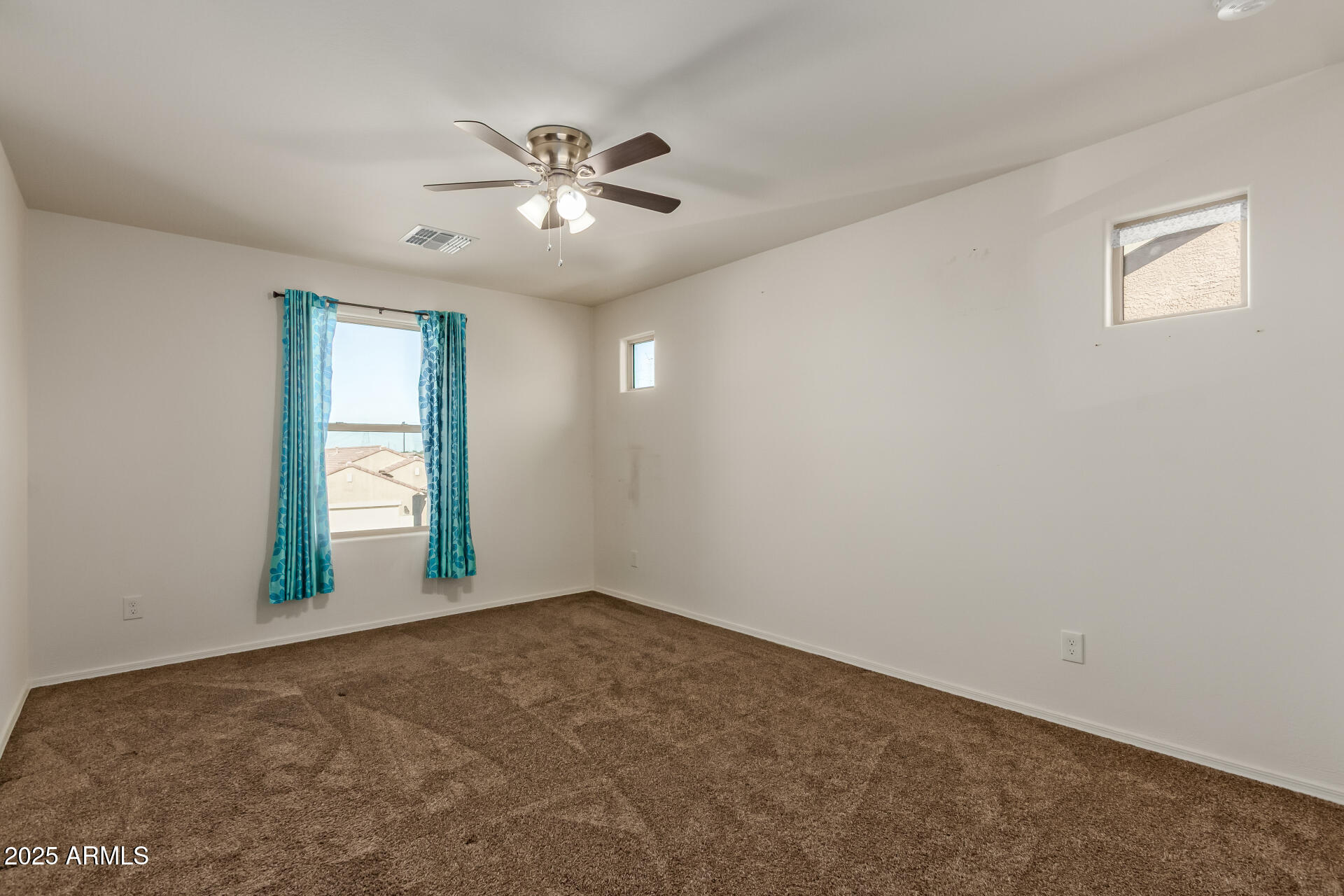 11603 West Calavar Road El Mirage, AZ 85335 - Photo 21 of 38 an empty room with windows and fan