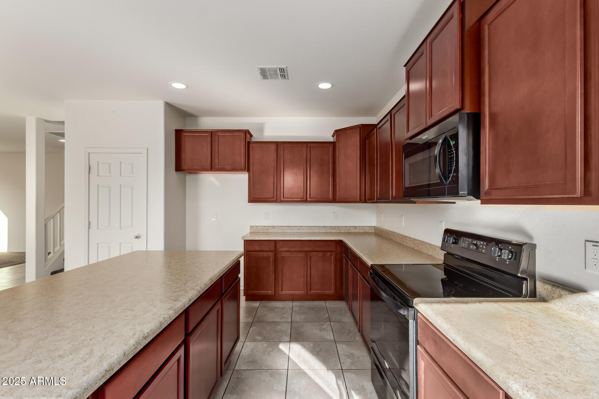 11603 West Calavar Road El Mirage, AZ 85335 - Photo 33 of 38 a kitchen with stainless steel appliances granite countertop a sink stove and refrigerator
