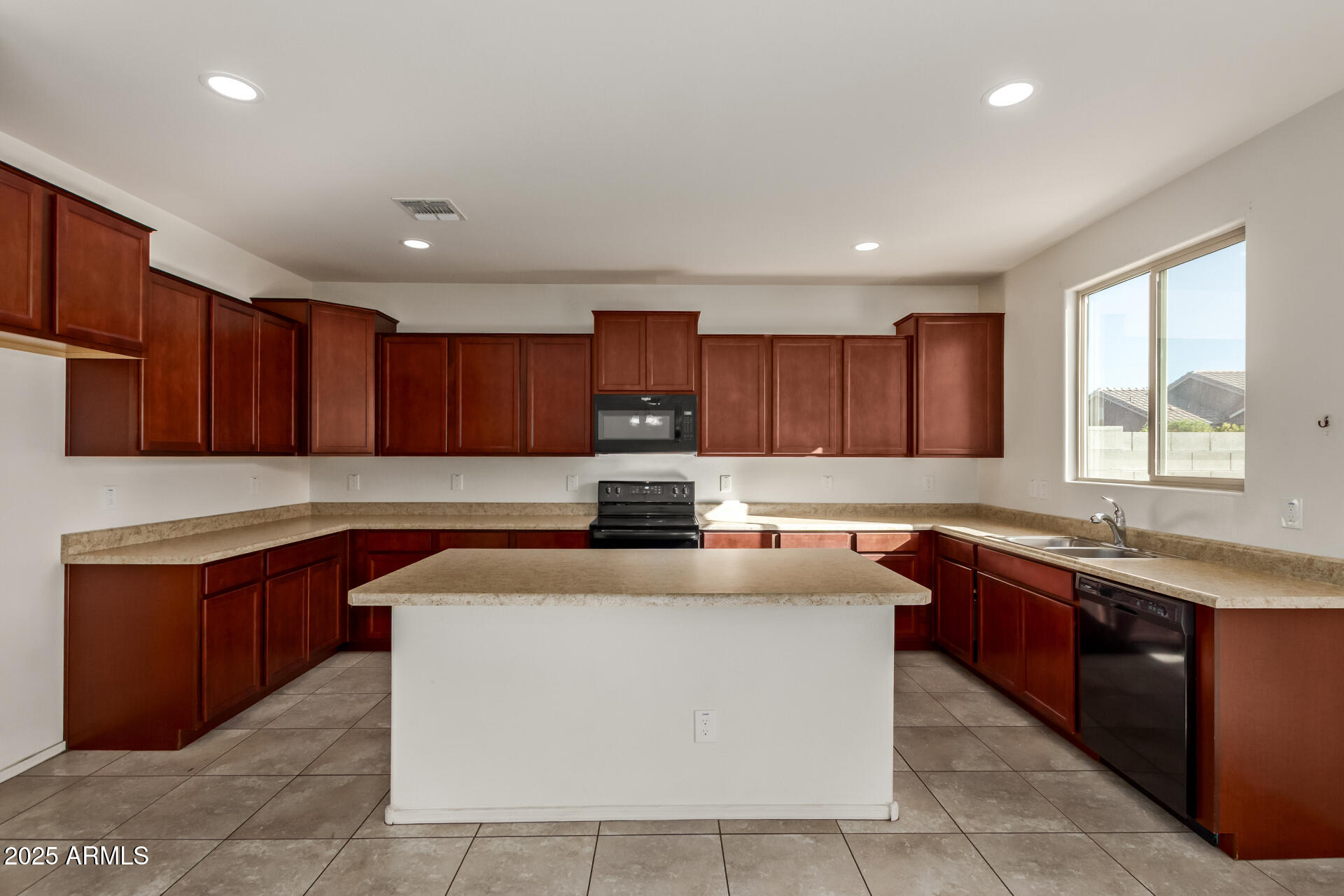 11603 West Calavar Road El Mirage, AZ 85335 - Photo 34 of 38 a kitchen with stainless steel appliances granite countertop a sink counter space cabinets and a large window