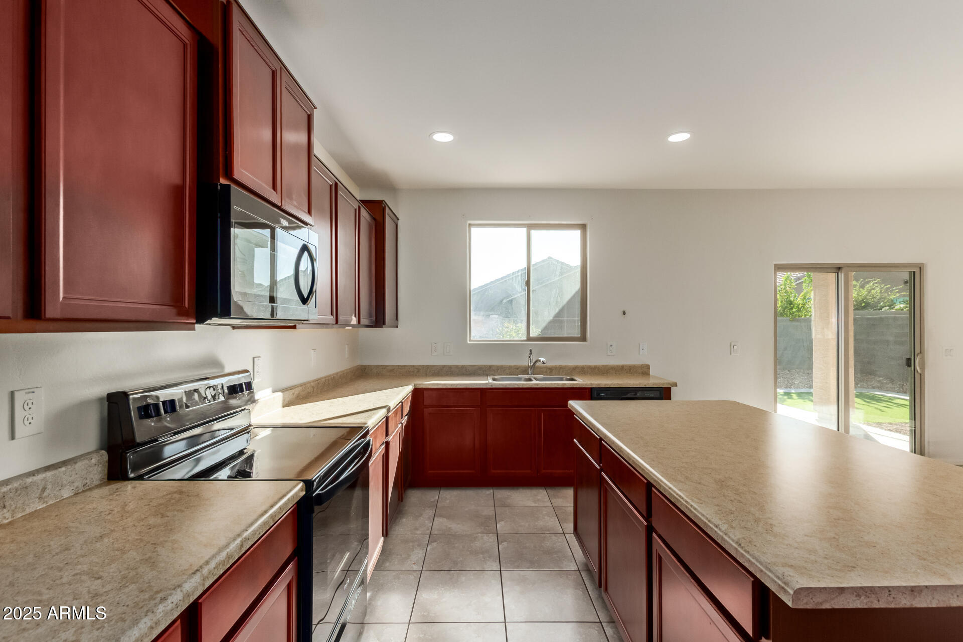 11603 West Calavar Road El Mirage, AZ 85335 - Photo 5 of 38 a kitchen with a stove a sink and a refrigerator