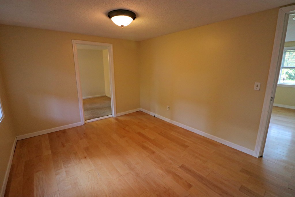 471 Plumtree Road Springfield, MA 01118 - Photo 4 of 15 an empty room with wooden floor and windows