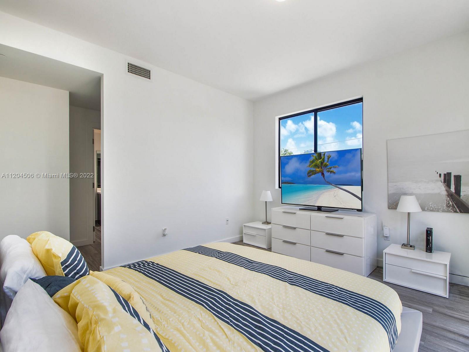2955 Bird Avenue, Unit PHA Miami, FL 33133 - Photo 15 of 33 a bedroom with a bed and a flat screen tv