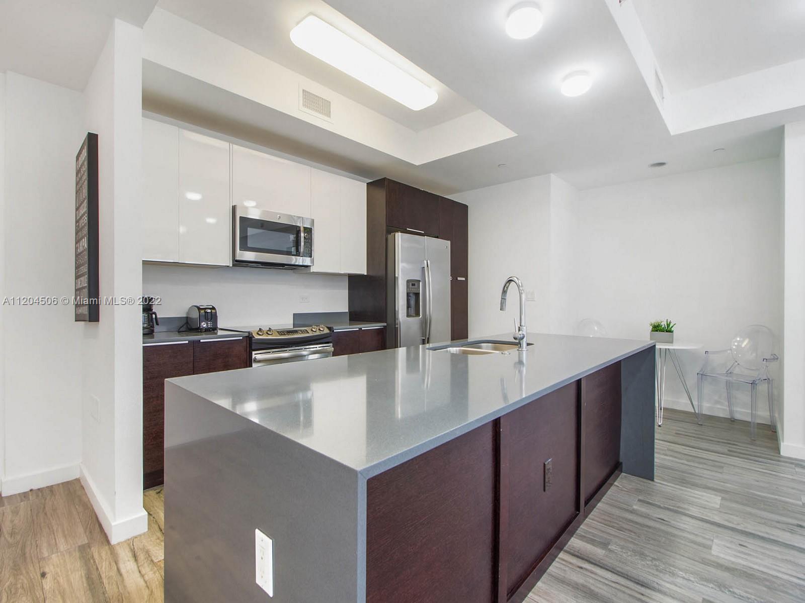 2955 Bird Avenue, Unit PHA Miami, FL 33133 - Photo 5 of 33 a large kitchen with stainless steel appliances a sink and a counter top space