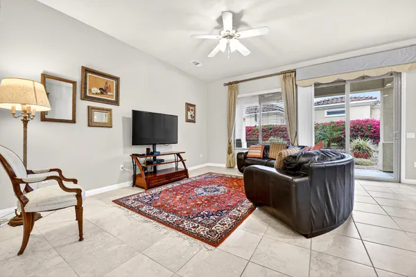 a living room with furniture a flat screen tv and a window