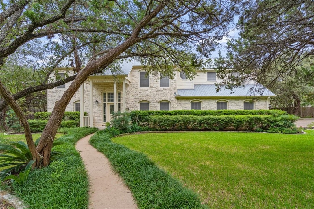 a front view of a house with a yard and trees
