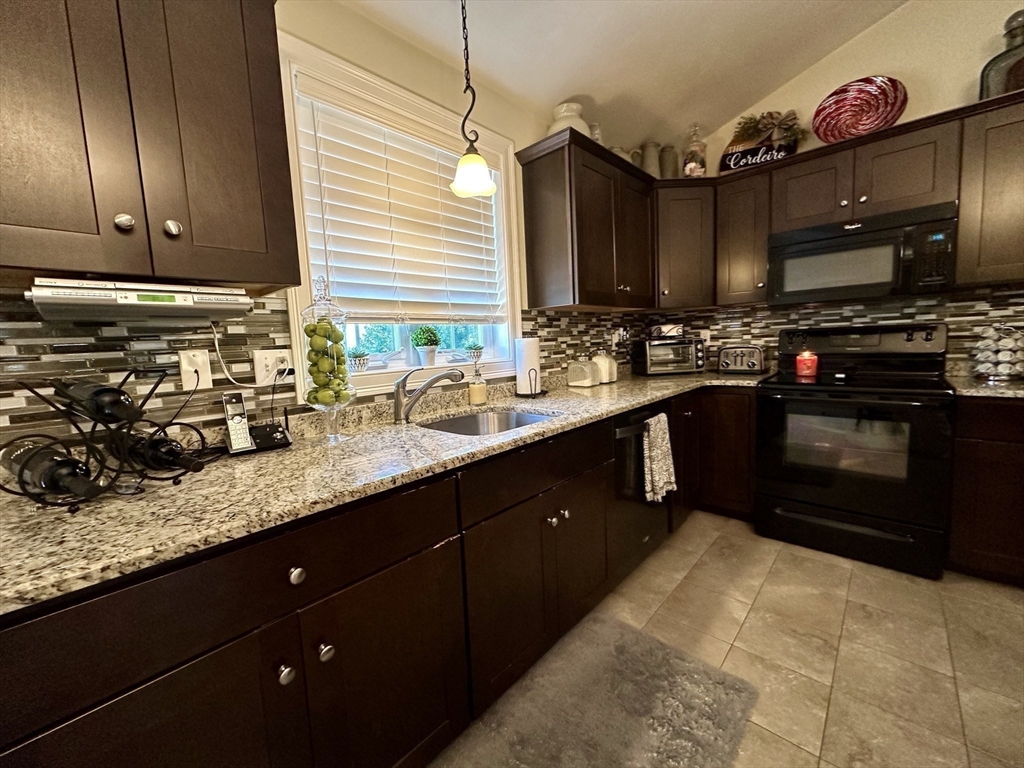 115 Bronson Fall River Fall River, MA 02724 - Photo 15 of 37 a kitchen with stainless steel appliances granite countertop a sink stove and cabinets