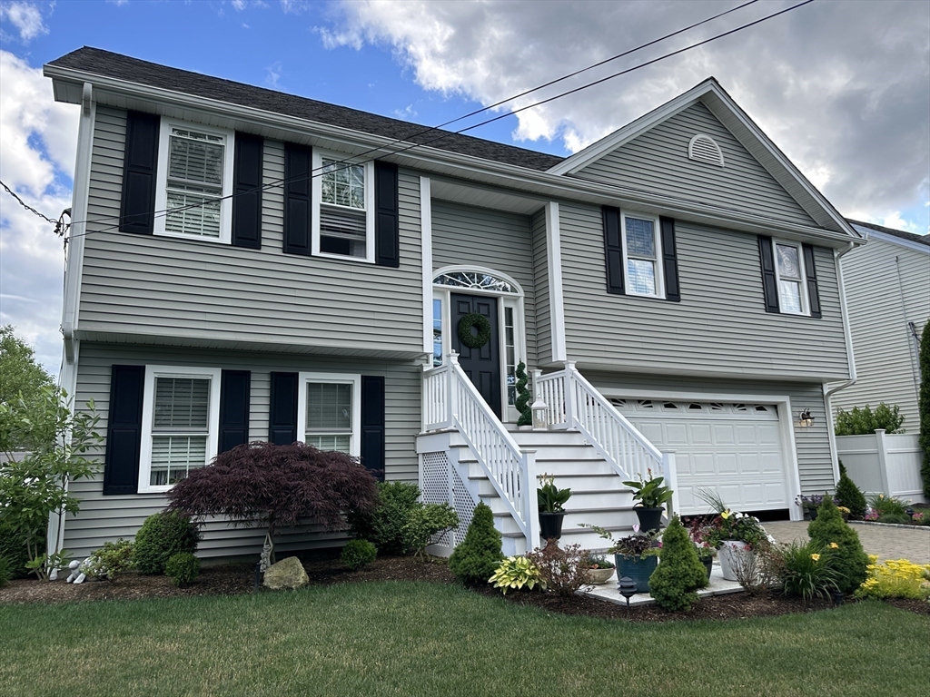 115 Bronson Fall River Fall River, MA 02724 - Photo 2 of 37 a front view of a house with a garden and plants