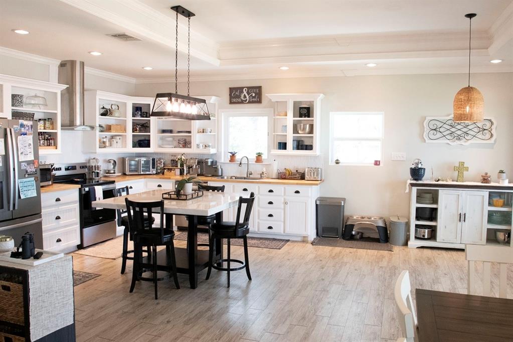 298 Redbud A Mexia, TX 76667 - Photo 13 of 40 a kitchen with stainless steel appliances kitchen island granite countertop a table chairs and a wooden floor