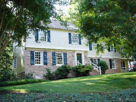 a front view of a house with a yard and trees