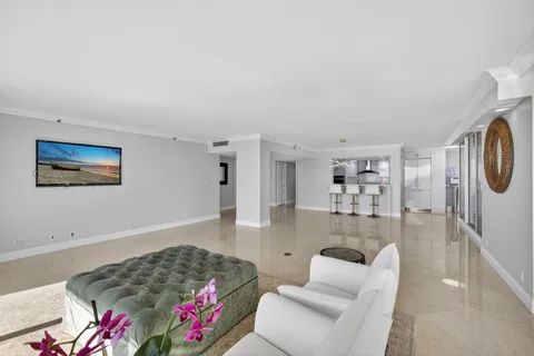 a living room with furniture and floor to ceiling windows