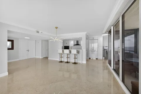 a large white kitchen with a large window and refrigerator