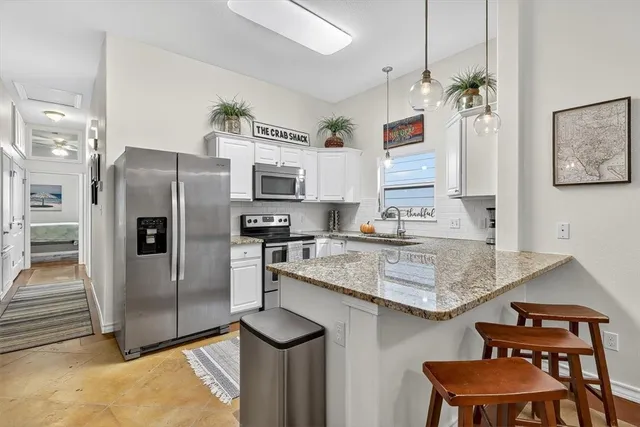 a kitchen with stainless steel appliances granite countertop a sink refrigerator and microwave