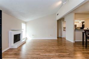 a view of empty room with wooden floor and fireplace