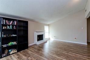 12802 Midway Road, Unit 2003 Dallas, TX 75244 - Photo 11 of 28 a view of empty room with wooden floor and book shelf