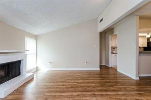 12802 Midway Road, Unit 2003 Dallas, TX 75244 - Photo 15 of 28 a view of an empty room with wooden floor fireplace and a window