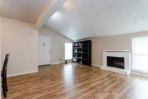 12802 Midway Road, Unit 2003 Dallas, TX 75244 - Photo 17 of 28 an empty room with wooden floor fireplace and windows