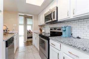 12802 Midway Road, Unit 2003 Dallas, TX 75244 - Photo 7 of 28 a kitchen with stainless steel appliances granite countertop a stove microwave and sink