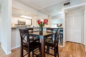 12802 Midway Road, Unit 2003 Dallas, TX 75244 - Photo 9 of 28 a view of a dining room with furniture and wooden floor