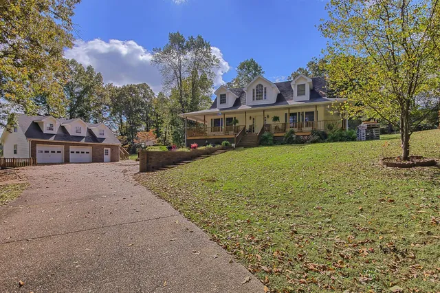 a view of house with yard and car parked