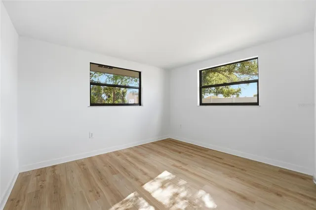 a view of empty room with wooden floor