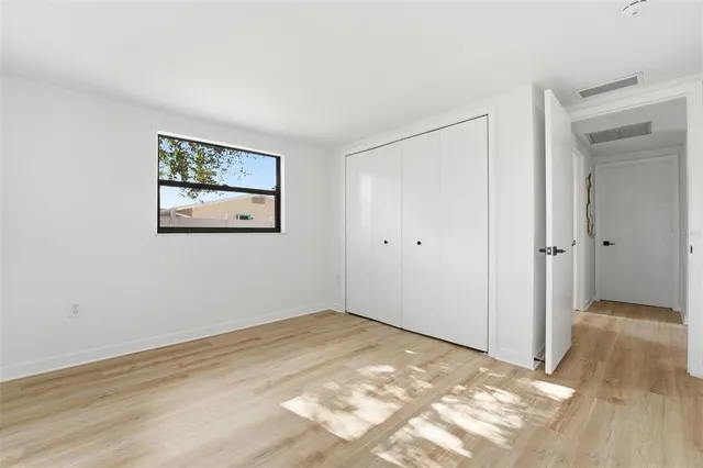 a view of empty room with wooden floor
