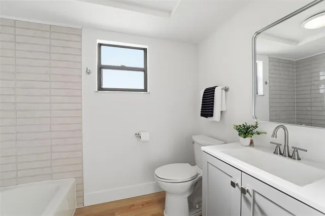 a bathroom with a sink mirror and toilet