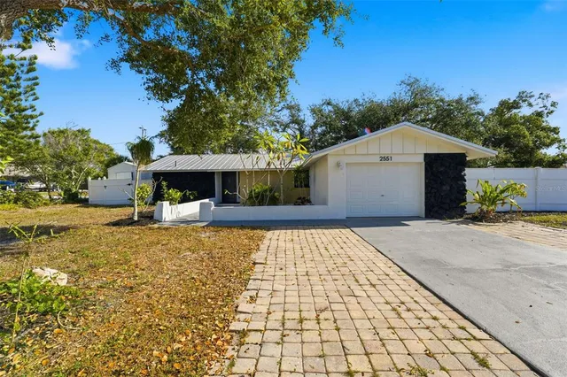 a front view of a house with a yard and a garden