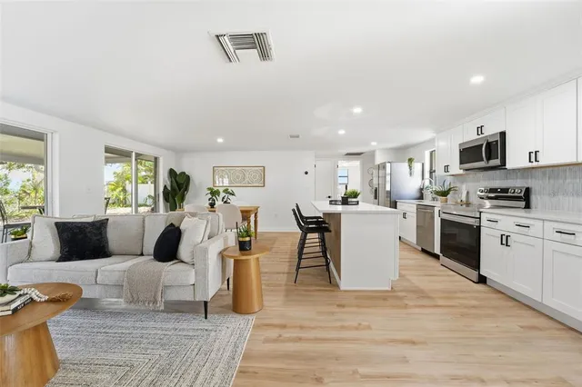 a living room with furniture and kitchen view
