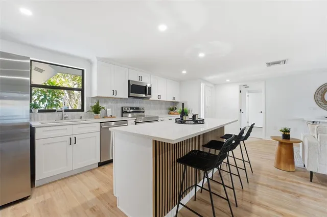 a kitchen with cabinets a sink a window and appliances