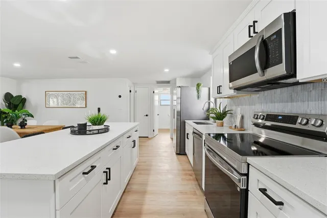 a kitchen with stainless steel appliances a sink dishwasher stove microwave and cabinets