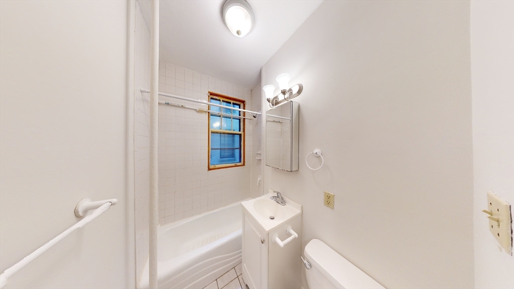 32 Sidlaw Road, Unit 7 Boston, MA 02135 - Photo 9 of 10 a bathroom with a toilet a sink and mirror