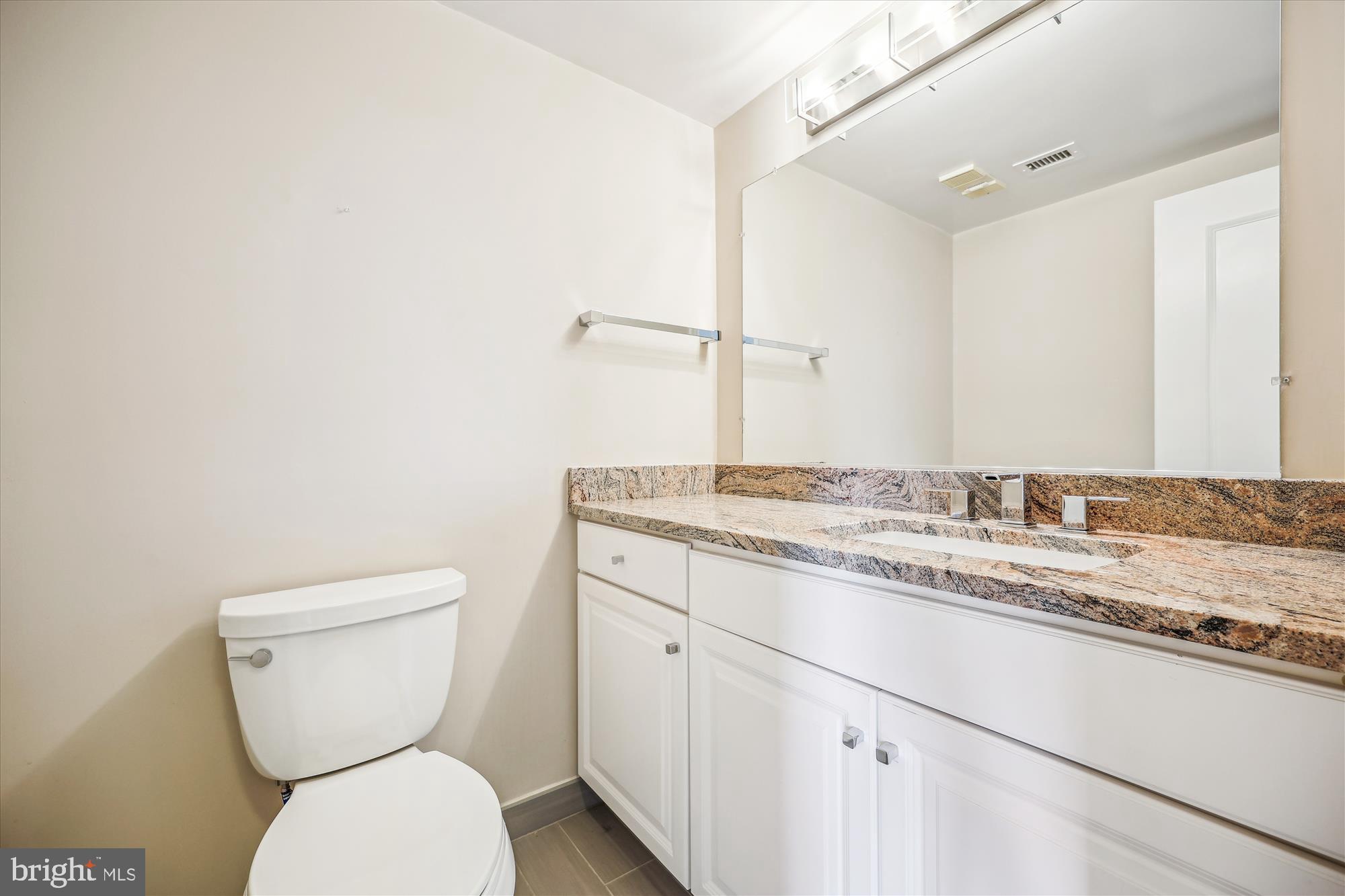 5800 Nicholson Lane, Unit 1908 Rockville, MD 20852 - Photo 17 of 35 a bathroom with a granite countertop toilet sink and mirror