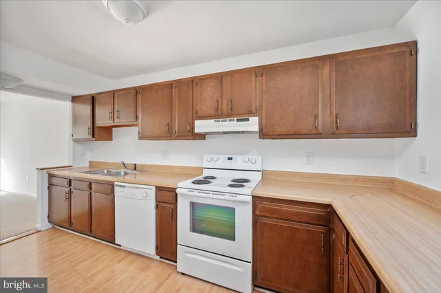 a kitchen with a sink stove top oven and cabinets