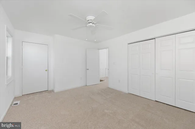 a view of a room with a window and ceiling fan