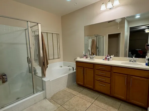a bathroom with a double vanity sink a large mirror and shower