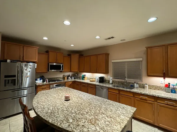 a kitchen with stainless steel appliances granite countertop a sink refrigerator and cabinets
