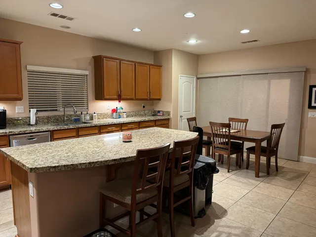 a kitchen with a stove a sink a dining table and chairs