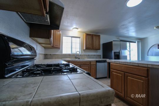 1645 Porter Street Ridgecrest, CA 93555 - Photo 12 of 35 a kitchen with a stove a sink and a microwave
