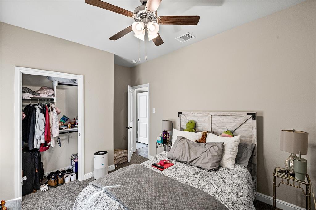 2373 Briscoe Rnch Drive Weatherford, TX 76087 - Photo 22 of 38 a bedroom with a bed and a chandelier